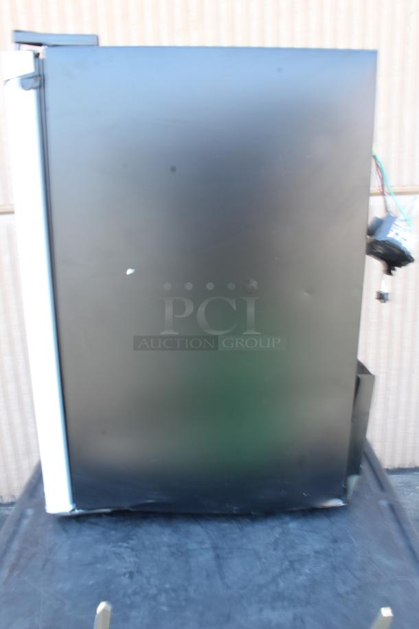 Side view of a black vending machine showing some wear and tear, wires exposed, no visible brand marking.