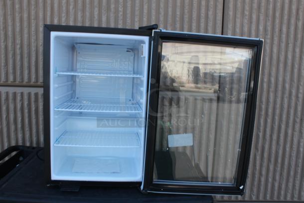 Compact glass-door fridge, clean interior, three wire shelves, black frame, good condition. Suitable for beverages.