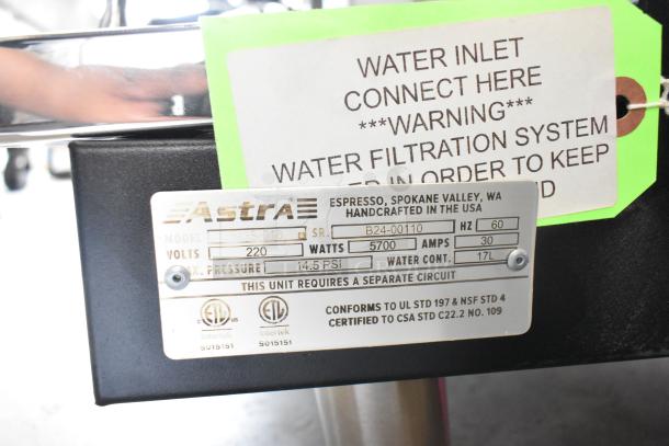 Astra 3S-018 espresso machine info plate showing model, voltage, and certifications. Includes caution and filtration tags.