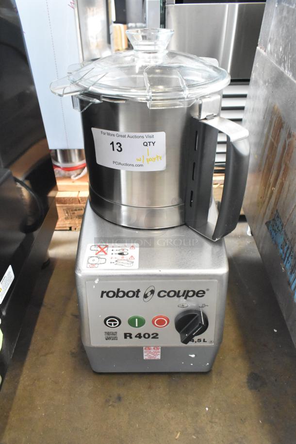 Brand new Robot Coupe R402 commercial food processor with metal bowl, continuous feed head. Includes discs and dicing kit.