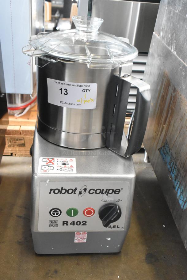 Brand new Robot Coupe R402 food processor, scratch and dent, with bowl, continuous feed head, and multiple discs.