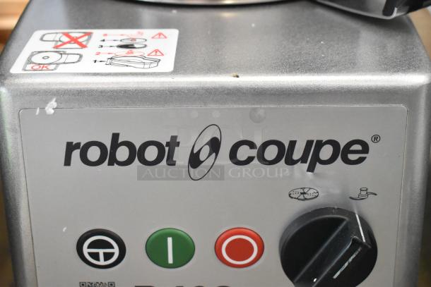 Brand new Robot Coupe R402 food processor, with minor scratches. Features bowl, feed head, discs, and dicing kit.