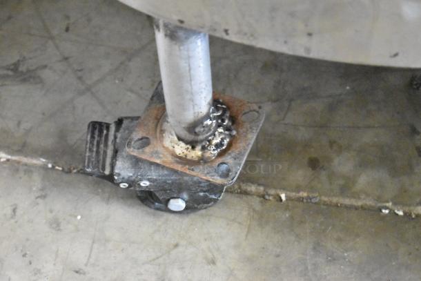 Groen AH-1E-40 stainless steel steam kettle caster detail, showing wear but functional, on a commercial floor.