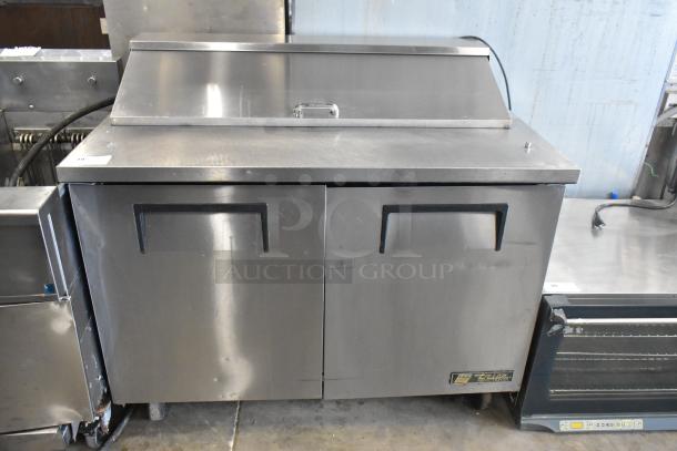 True TSSU-48-12 stainless steel sandwich salad prep table on commercial casters. 115 Volts, 1 Phase, well-maintained.