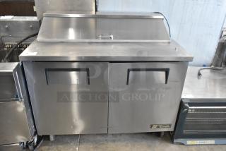 True TSSU-48-12 stainless steel sandwich salad prep table on commercial casters. 115 Volts, 1 Phase, well-maintained.