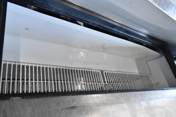 True TSSU-48-12 stainless steel prep table interior, clean with wire racks. Bain Marie top, on commercial casters.