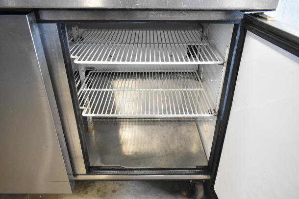 True TSSU-48-12 stainless steel prep table with open storage, shelves, and commercial casters; 115 volts, 1 phase.