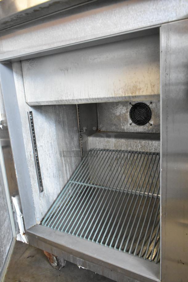 Leader ESSM48 stainless steel commercial sandwich salad prep table, interior view showing grill shelf, fan, on casters.