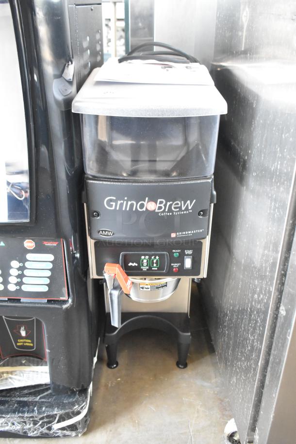 Grindmaster Grind N Brew stainless steel commercial coffee grinder and maker with hot water dispenser and metal brew basket.