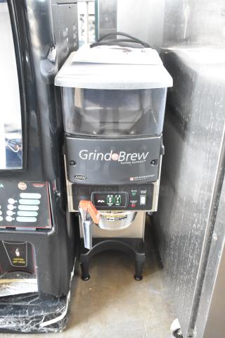 Grindmaster Grind N Brew stainless steel commercial coffee grinder and maker with hot water dispenser and metal brew basket.