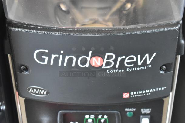 Grindmaster Grind N Brew stainless steel commercial coffee maker with grinder, hot water dispenser, metal brew basket.