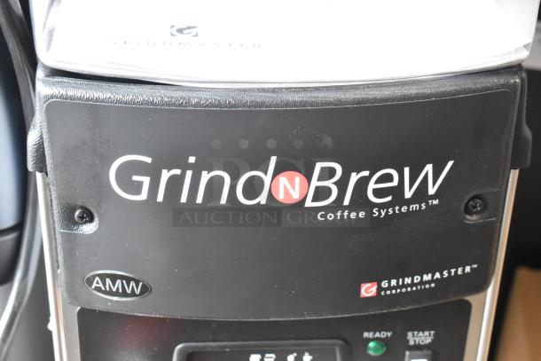 Grindmaster Grind N Brew stainless steel coffee maker and grinder with hot water dispenser and metal brew basket.