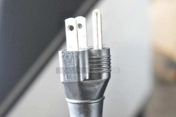 Close-up image of a black power plug compatible with the Cecilware LTB-105-1R iced tea machine, indicating it operates on 120 volts.
