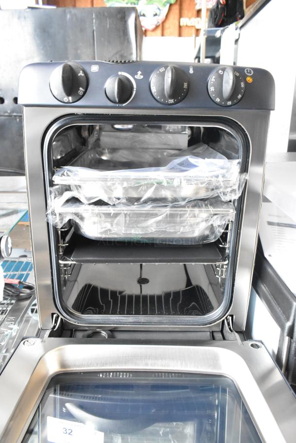 Brand new Electrolux OTS100 countertop mini combi steamer, 110V, 1 phase, metal finish, with plastic-wrapped trays inside.