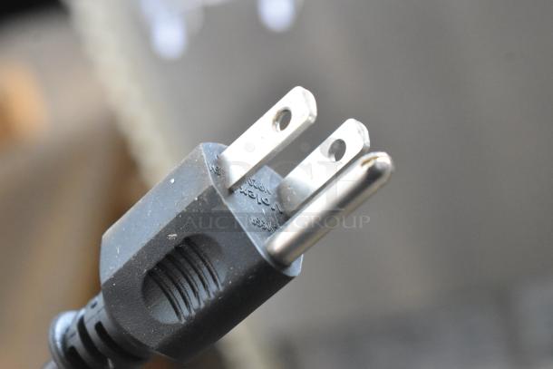 Black electrical plug for Crathco E27/E29-4 beverage machine, 115 volts, 1 phase. Close-up view.