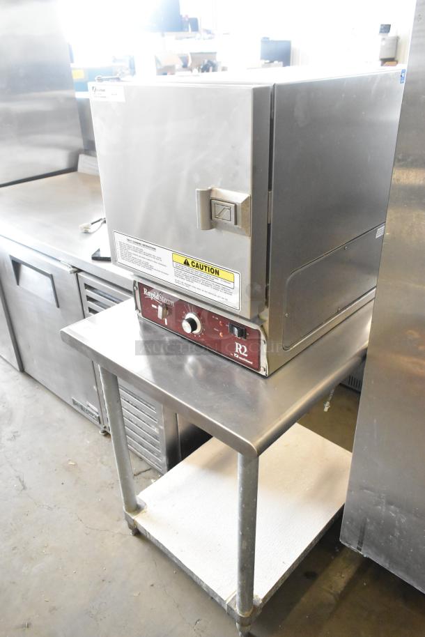 Southbend R2 RapidSteam stainless steel steam cabinet, gas-powered, on a stainless steel table; features caution labels.