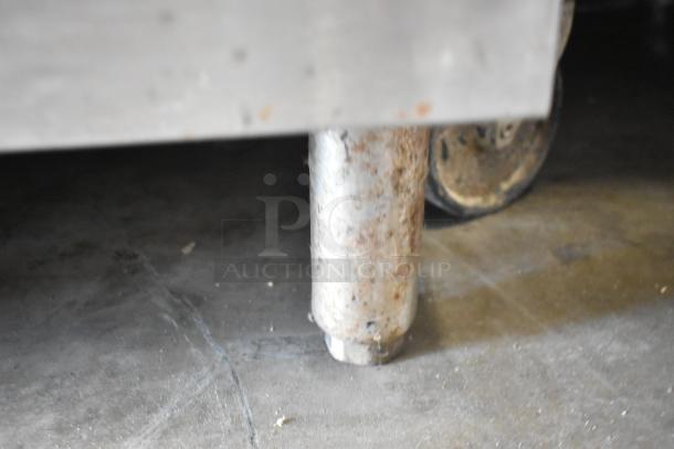 Vulcan VSX24G stainless steel steam cabinet leg, showing wear and rust, on a concrete floor.