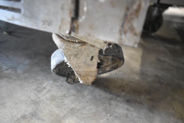 Stainless steel commercial undercounter cooler on worn casters, by Beverage Air. 115 volts, 1 phase. Visible wear on wheels.