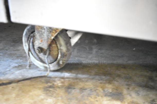 Southbend X460DD commercial stove caster. Rust visible; part of a 10-burner range with ovens and shelf.