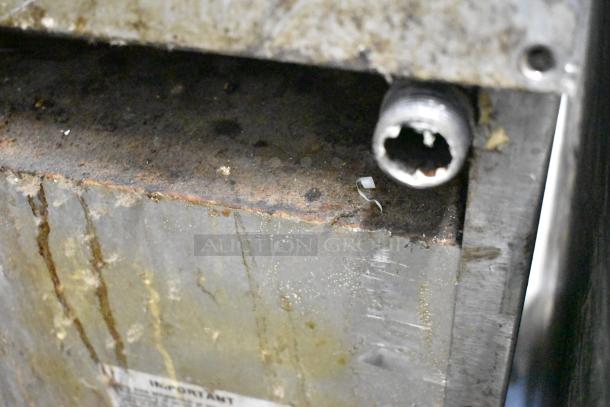 Southbend X460DD stainless steel commercial gas range close-up, showing surface wear and pipe connection.