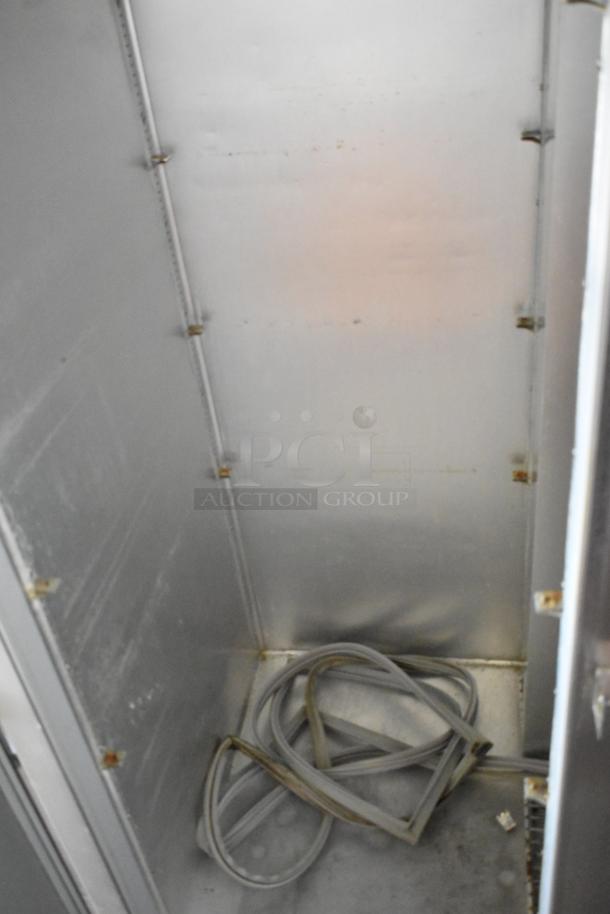 Beverage Air E Series stainless steel commercial 2-door reach-in cooler. Left door faulty. On commercial casters. Interior view.