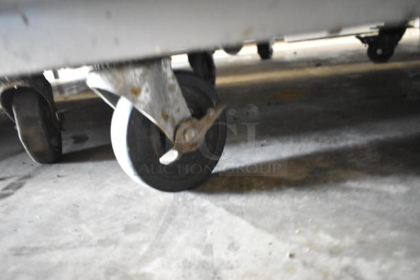 Beverage Air E Series commercial cooler caster, showing wear. Stainless steel, 2-door, left door faulty, on casters.