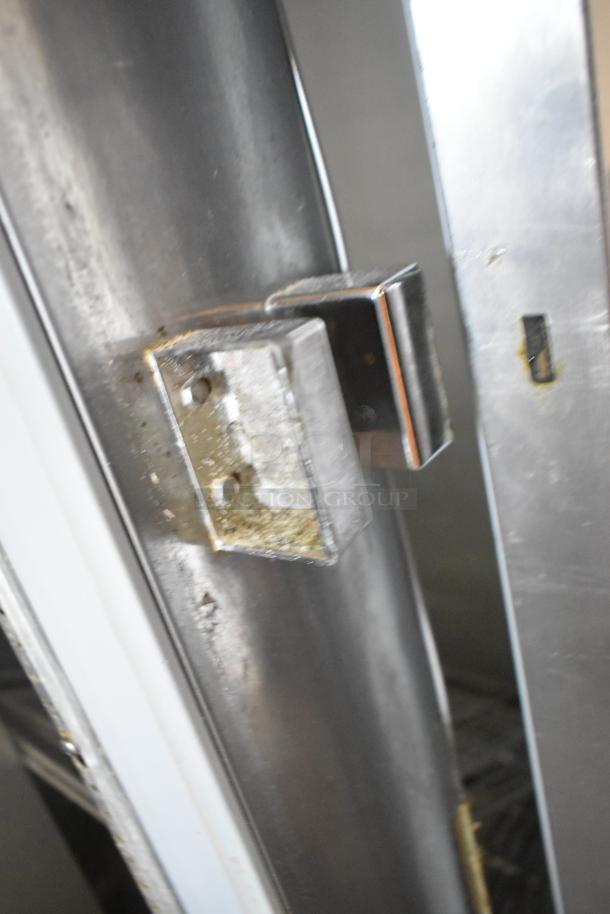 Beverage Air E Series stainless steel 2-door reach-in cooler with a latch issue on left door, placed on commercial casters.