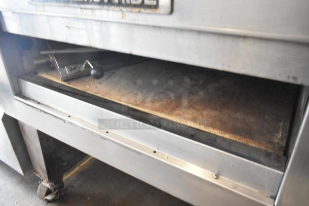 Bakers Pride EP-2-2828 SuperDeck pizza oven, stainless steel, 2 decks, on metal legs with casters, lower door needs reattachment.