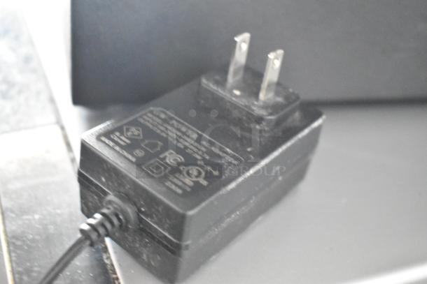 Electrical plug labeled "IC-F012ST" with safety certifications, black, attached to a cord.