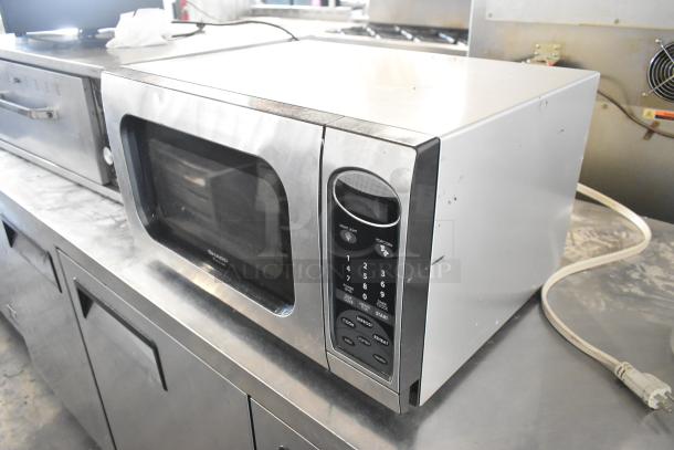 Sharp R-405KS-T countertop microwave oven with plate, 120 volts, used condition, stainless finish, visible control panel.