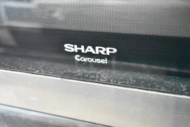 Sharp R-405KS-T Countertop Microwave Oven with plate, 120V 1-phase, logo detail, moderate wear.