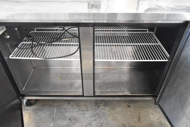 Migali C-U72R stainless steel 3-door undercounter cooler with commercial casters, shelving visible, 115V, 1 phase, used condition.