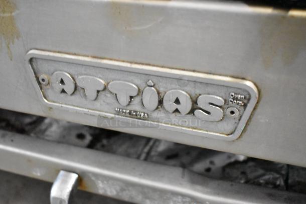 Attias stainless steel commercial countertop gas charbroiler grill with "Made in USA" label, showing some wear.