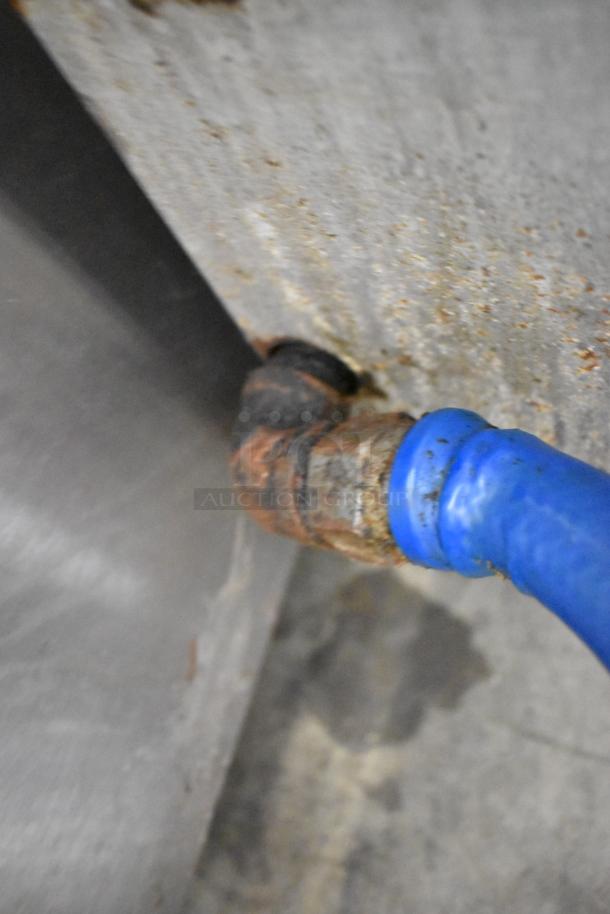 Attias stainless steel gas charbroiler grill, showing rusted pipe connection and blue hose. Needs repair.