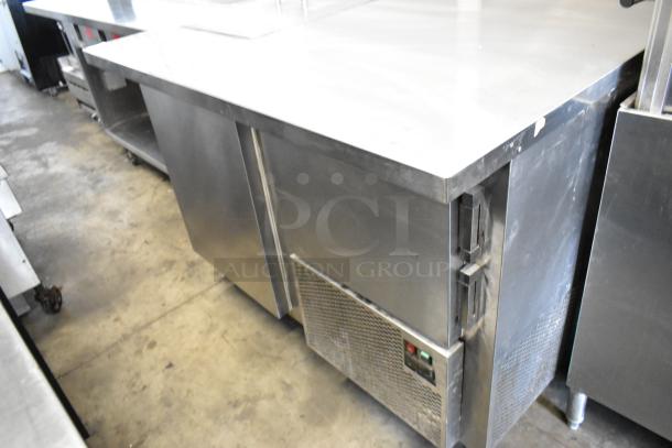Stainless steel commercial prep table with 2 doors, on casters. Features 115V, 1 phase power. Shows moderate use.