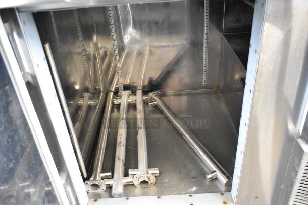 Stainless steel commercial prep table interior view, showing adjustable shelving hardware. 115 volts, 1 phase power. Condition appears gently used.