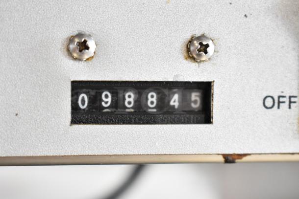Noble Wareforce I-E dishwasher meter showing 098845 cycles, indicating usage level. Silver panel with visible screws.