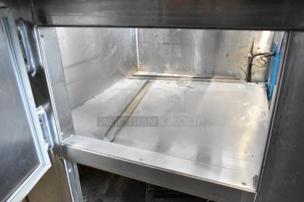 Universal Coolers stainless steel commercial prep table with commercial casters, 115 volts, 1 phase. Slight wear visible.