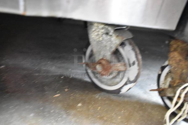 Universal Coolers stainless steel commercial prep table caster showing rust and wear, 115 volts, 1 phase.
