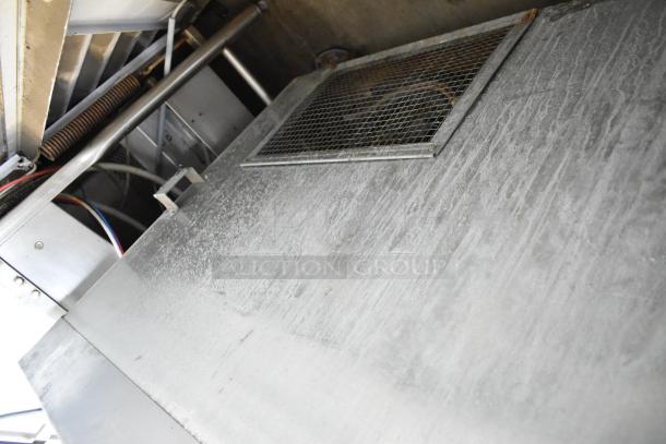Universal Coolers stainless steel commercial prep table on casters, 115V, 1 phase, surface wear visible.