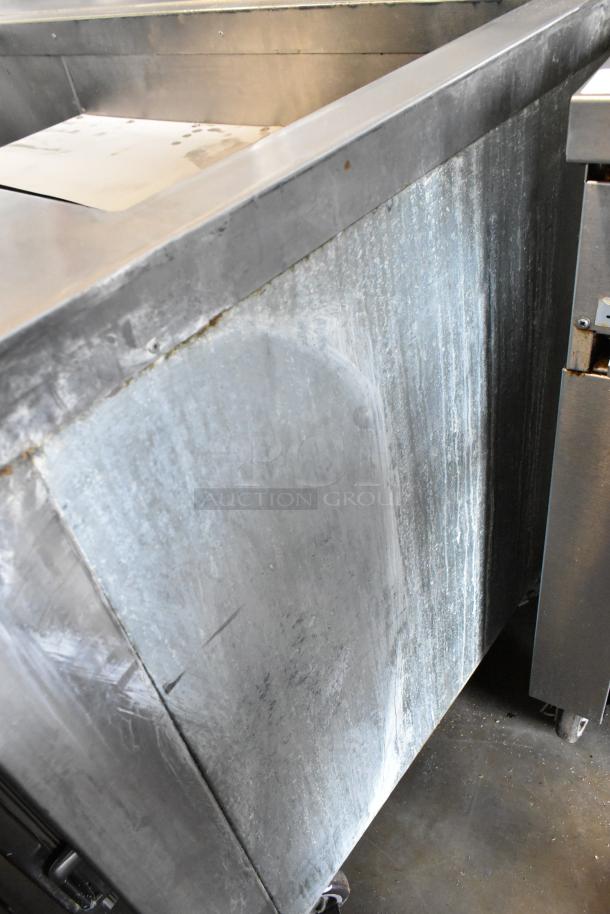 Universal Coolers stainless steel commercial prep table on casters, 115 volts, 1 phase, showing surface wear.