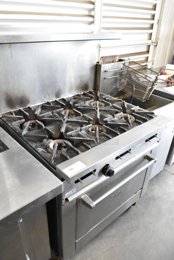 Garland SunFire stainless steel commercial gas range with 6 burners, oven, over shelf, backsplash, on casters, used condition.