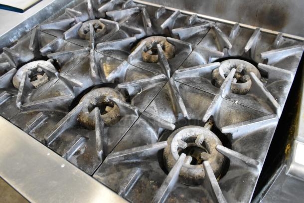 Garland SunFire 6-burner gas range with oven, over shelf, and backsplash. Stainless steel, on commercial casters. Used condition.