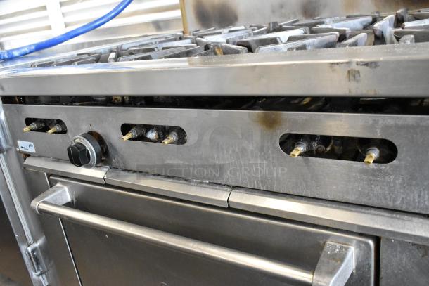 Garland SunFire stainless steel commercial gas range with 6 burners, oven, overshelf, backsplash, on casters. Well-used condition.