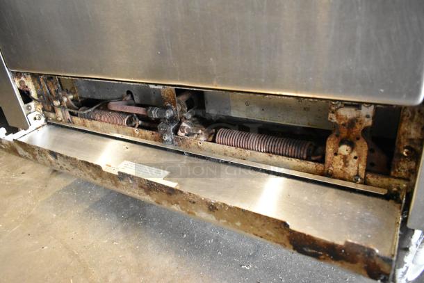 Garland SunFire stainless steel 6-burner gas range with oven, over shelf, backsplash, and casters. Visible wear and rust on components.