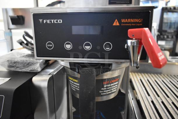 2025 Fetco CBS-1221 stainless steel coffee machine with hot water dispenser, metal brew basket, and warning labels.