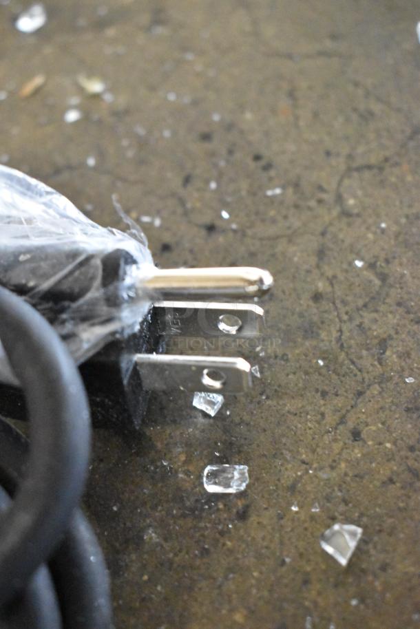 Close-up of a power plug on the ServIt 423PDW12D1 stainless steel pizza warmer. Plug is wrapped in plastic, shown with some glass fragments.