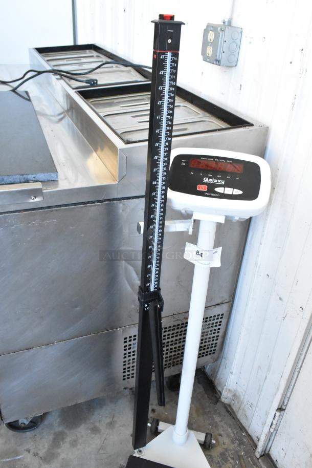 Galaxy 177MSD600 floor scale, black and white, metal construction, digital display, height measurement rod attached.