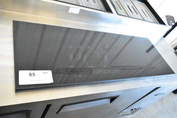 Black glossy countertop on stainless steel base, item tag with "85 QTY" for auction identification.