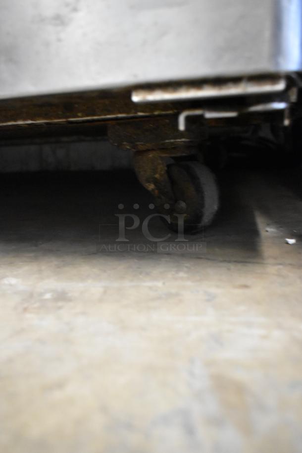 Bison MGF8402 stainless steel undercounter cooler with commercial casters shown in detail, highlighting one caster.